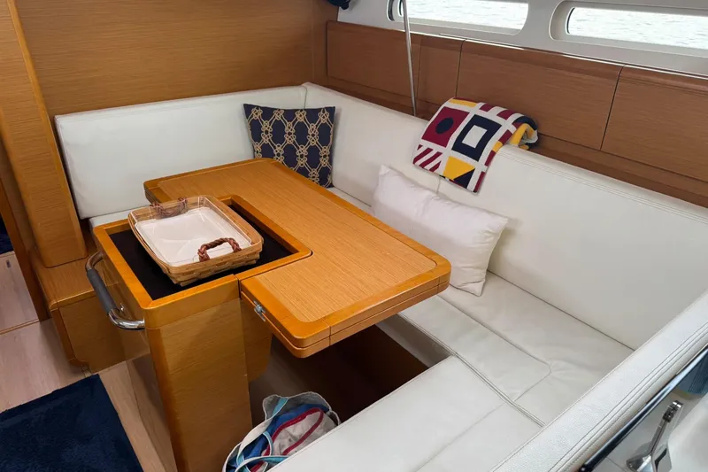 Slide: The Image of Cozy interior of 2013 Jeanneau 409 sailboat with wooden table and white seating. - 19