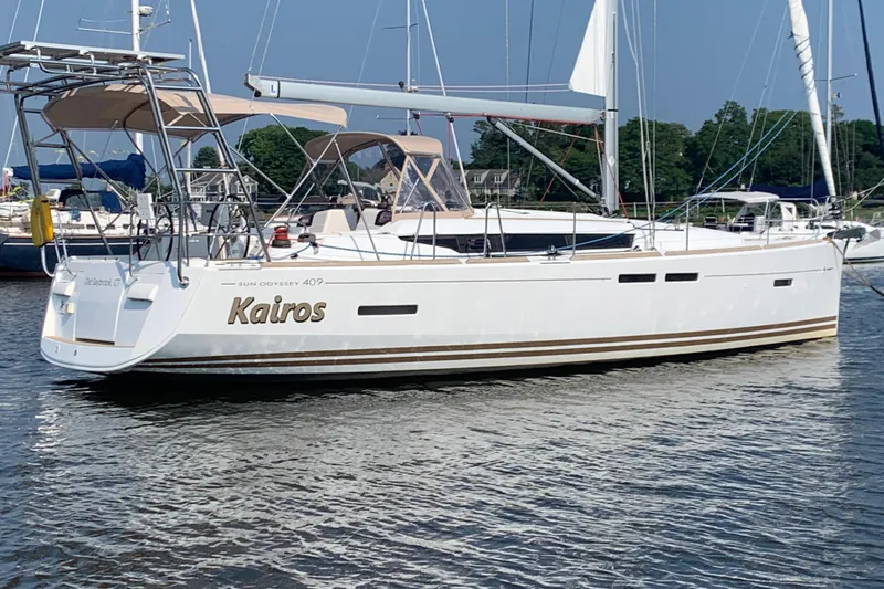 The Image of Jeanneau 409 sailboat "Kairos" docked in a marina, featuring sleek design and white hull. - 2