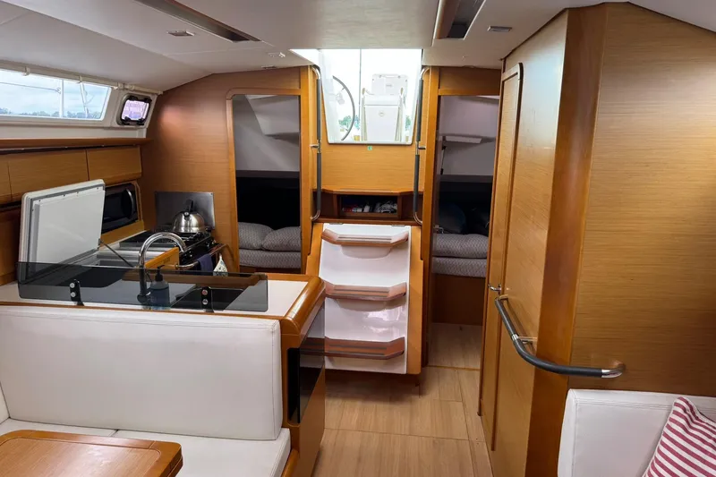 Slide: The Image of Interior of 2013 Jeanneau 409 sailboat, featuring modern kitchen and cozy sleeping area. - 22