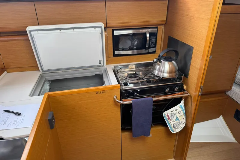 Slide: The Image of 2013 Jeanneau 409 yacht kitchen with stove, microwave, and open fridge. - 24