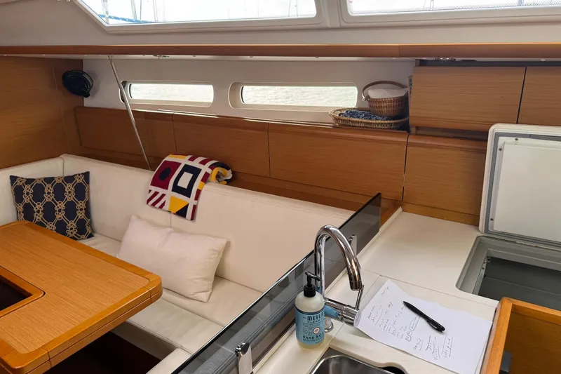 Slide: The Image of Interior of 2013 Jeanneau 409 sailboat with cozy seating and modern kitchen amenities. - 26