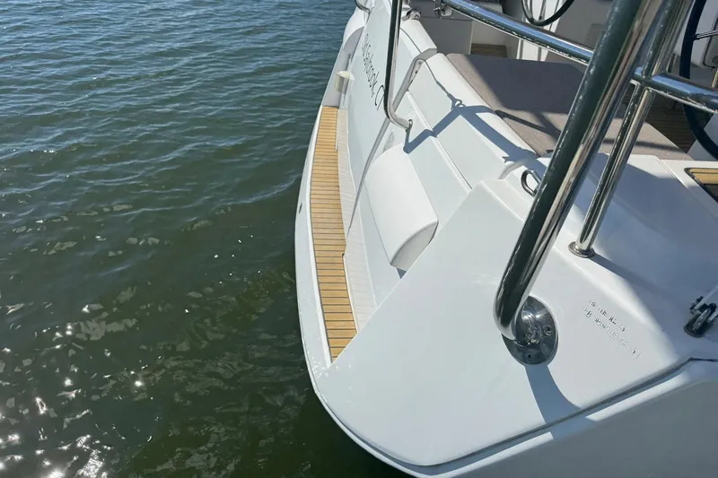 Slide: The Image of 2013 Jeanneau Sun Odyssey 409 yacht stern with teak deck, floating on calm water. - 38