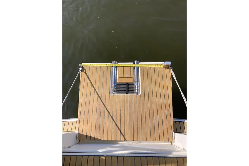 Slide: The Image of Teak swim platform on 2013 Jeanneau Sun Odyssey 409 yacht, featuring ladder and railing. - 40