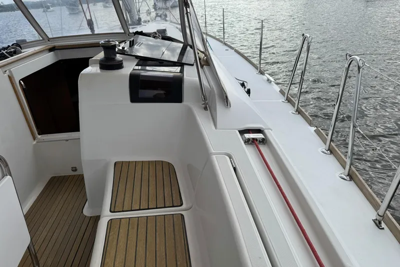 Slide: The Image of Jeanneau 409 sailboat deck with wooden seating and ocean view. - 9