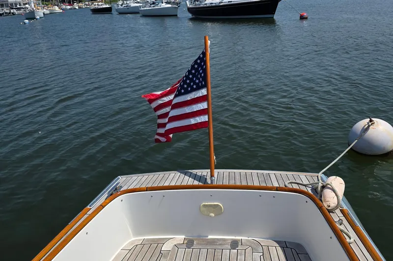 Slide: The Image of 2006 Nordic Star 33 Runabout with American flag on calm waters. - 10