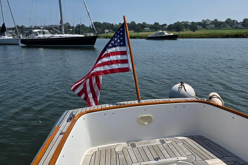 Slide: The Image of 2006 Nordic Star 33 Runabout with American flag on calm water. - 7