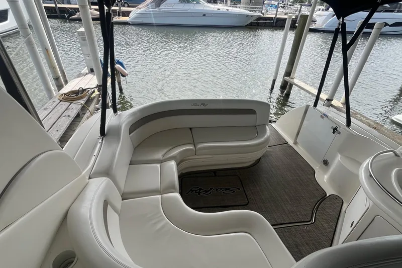 Slide: The Image of 2004 Sea Ray 340 Sundancer boat interior with white seating and water view. - 12