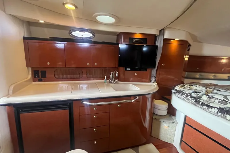 Slide: The Image of 2004 Sea Ray 340 Sundancer interior with kitchenette, TV, and bed. - 24