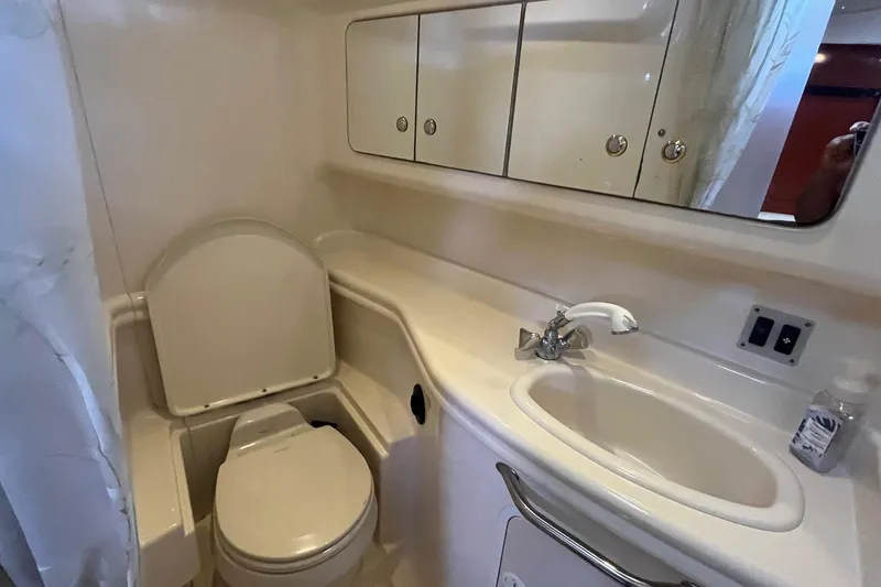 Slide: The Image of 2004 Sea Ray 340 Sundancer bathroom with toilet, sink, and mirrored cabinet. - 34