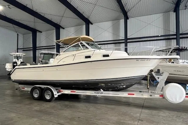 The Image of 1997 Pursuit 2870 Walkaround boat on trailer in indoor storage facility. - 0