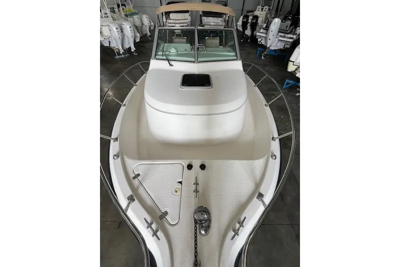 Slide: The Image of 1997 Pursuit 2870 Walkaround boat, white deck, docked indoors, view from bow. - 10