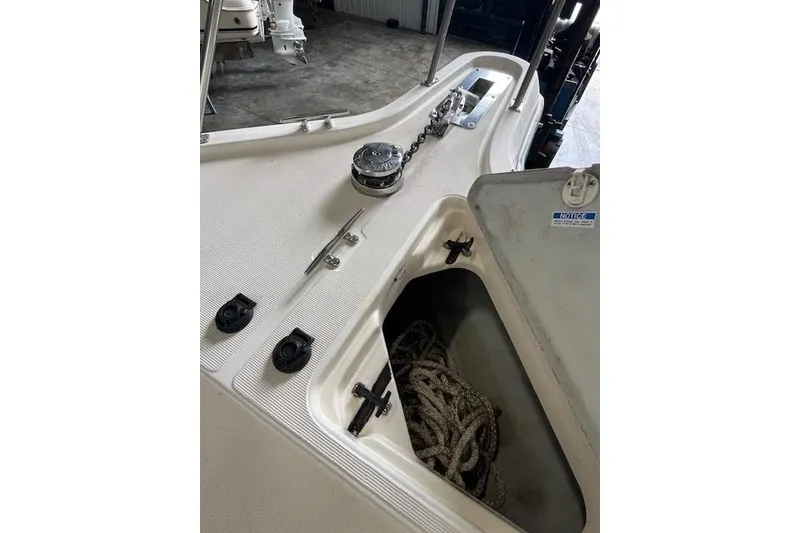 Slide: The Image of 1997 Pursuit 2870 Walkaround boat deck with anchor chain and storage compartment. - 11