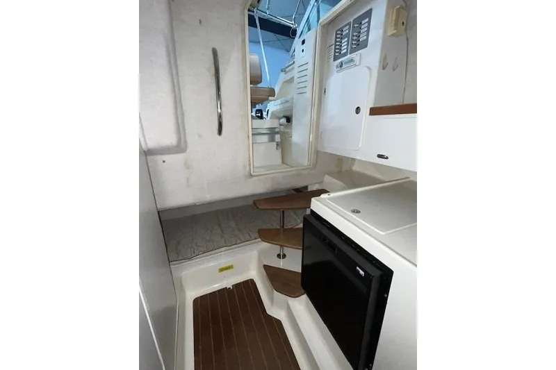 Slide: The Image of Interior of 1997 Pursuit 2870 Walkaround boat with compact kitchen and steps. - 14