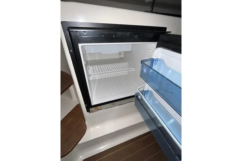 Slide: The Image of 1997 Pursuit 2870 Walkaround boat interior with open refrigerator. - 17