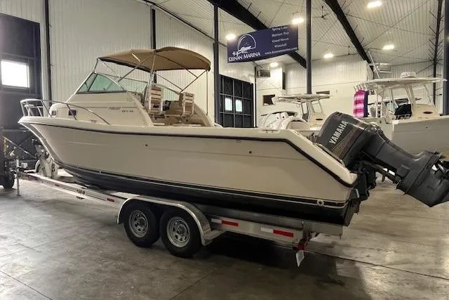 Slide: The Image of 1997 Pursuit 2870 Walkaround boat on trailer in indoor marina setting. - 2