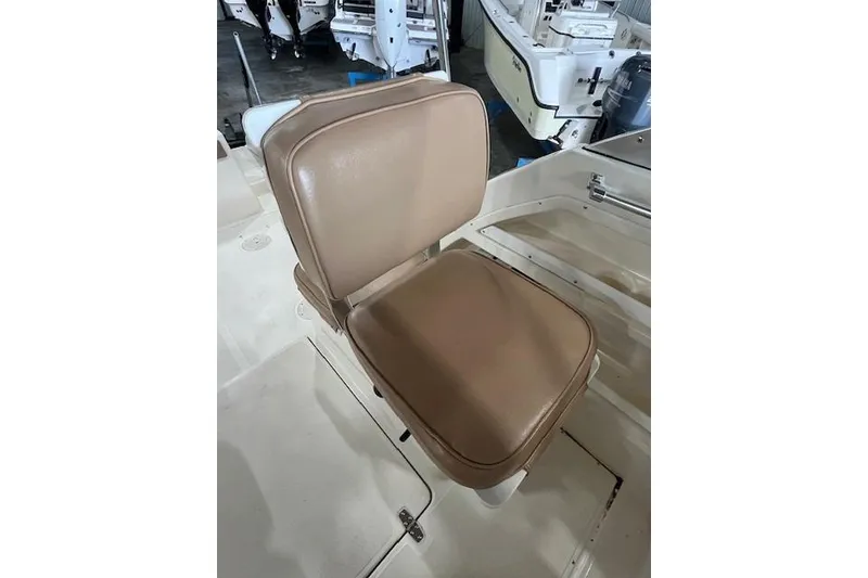 Slide: The Image of 1997 Pursuit 2870 Walkaround boat seat with tan upholstery in a marine setting. - 21