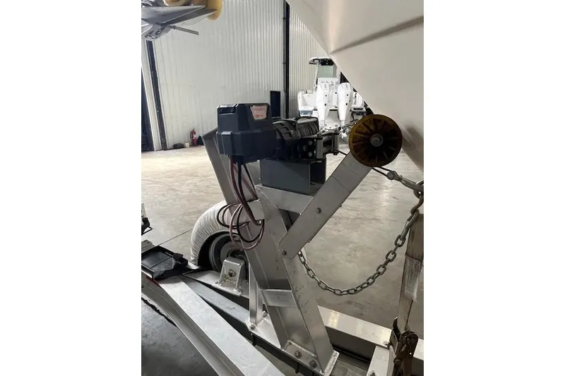 Slide: The Image of 1997 Pursuit 2870 Walkaround boat trailer with winch in a garage setting. - 24