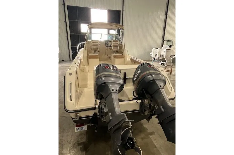 Slide: The Image of 1997 Pursuit 2870 Walkaround boat with dual Yamaha outboard motors in a storage facility. - 25