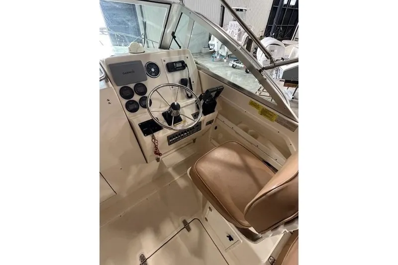 Slide: The Image of 1997 Pursuit 2870 Walkaround boat cockpit with steering wheel and control panel. - 5