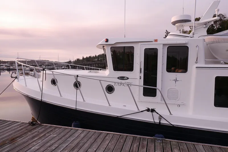 Slide: The Image of 2013 American Tug 395 docked at sunset, showcasing sleek design and modern features. - 10