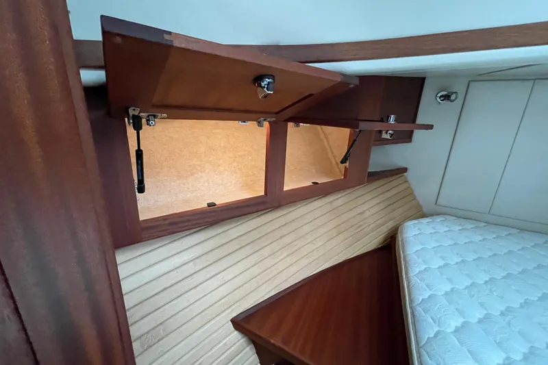 Slide: The Image of Interior of 2013 American Tug 395 with open wooden storage cabinets and a mattress. - 101