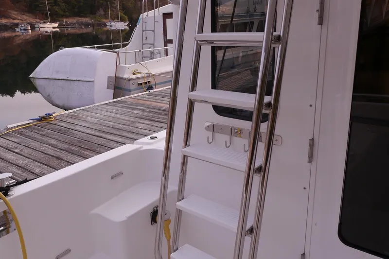 Slide: The Image of American Tug 395 (2013) docked, featuring a ladder and hooks on the deck. - 106