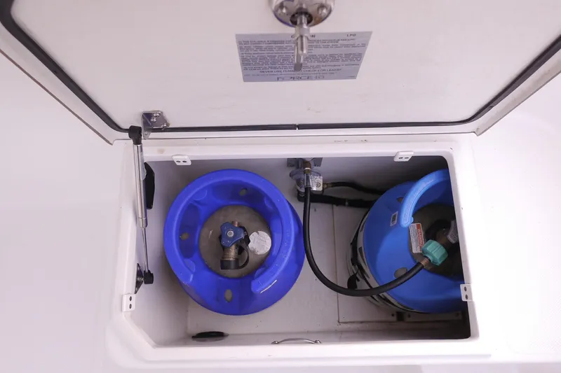 Slide: The Image of Storage compartment with two blue propane tanks on a 2013 American Tug 395 boat. - 107