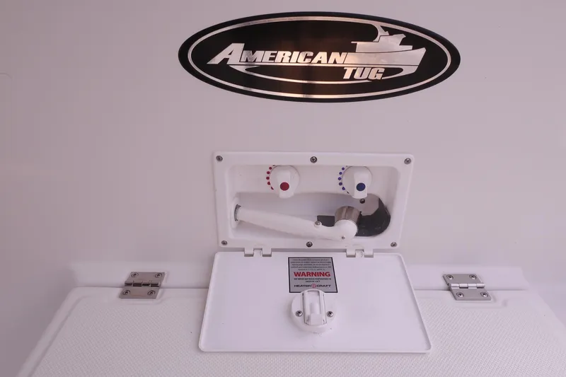 Slide: The Image of American Tug 395 (2013) water control panel with logo and warning label. - 108