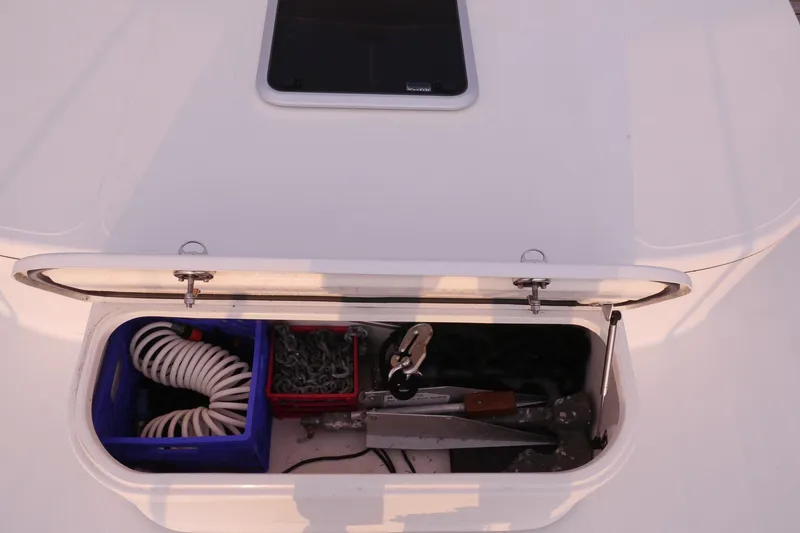Slide: The Image of Open storage compartment on 2013 American Tug 395 boat, containing coiled hose and anchor chain. - 114