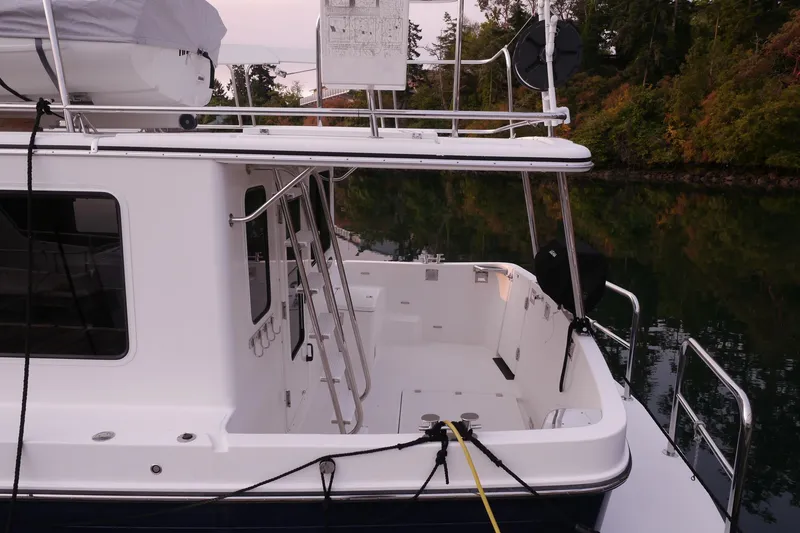 Slide: The Image of 2013 American Tug 395 boat docked, featuring a spacious deck and sleek design. - 12