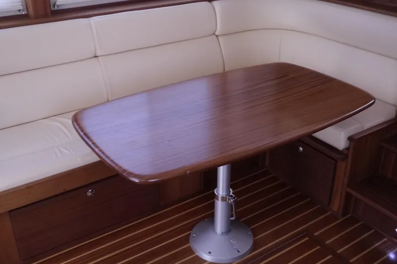 Slide: The Image of Interior of 2013 American Tug 395 with wooden table and cream seating. - 16
