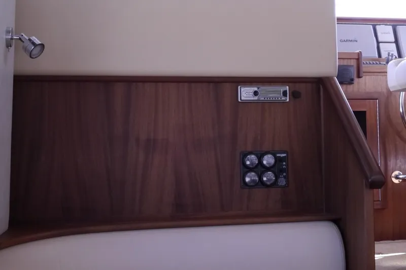 Slide: The Image of Interior view of 2013 American Tug 395, featuring wood paneling and control switches. - 18