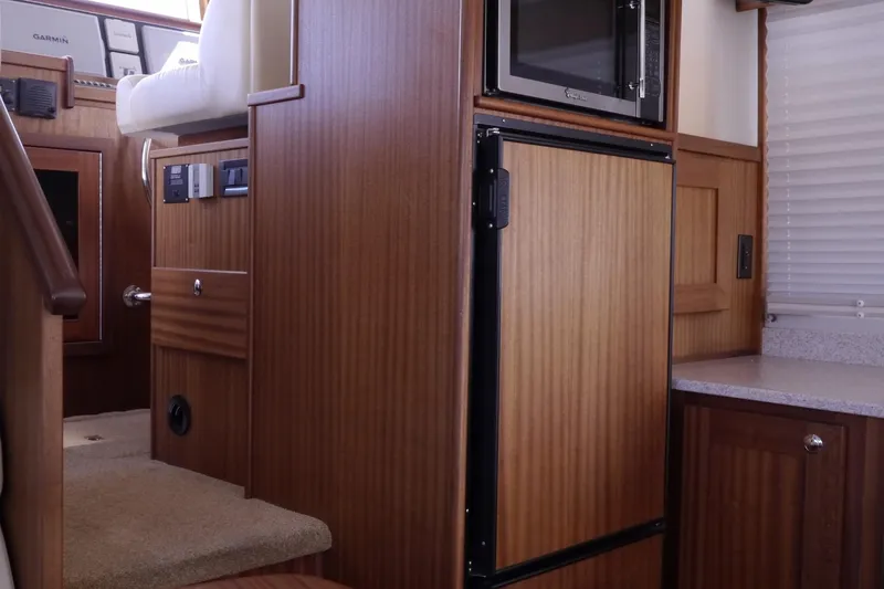 Slide: The Image of Interior of 2013 American Tug 395, featuring wood cabinetry and built-in appliances. - 22