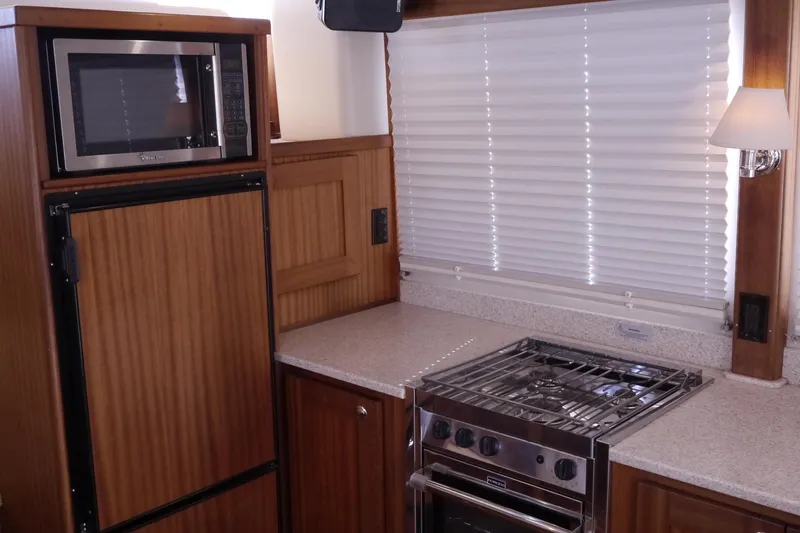 Slide: The Image of 2013 American Tug 395 galley with microwave, stove, and wood cabinetry. - 23