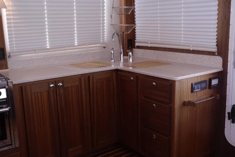 Slide: The Image of Interior of 2013 American Tug 395, featuring a wooden kitchen with modern fixtures. - 28