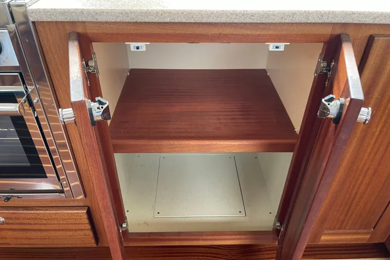 Slide: The Image of Open wooden cabinet in 2013 American Tug 395 boat interior. - 30