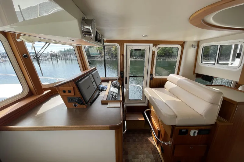 Slide: The Image of Interior of 2013 American Tug 395, featuring helm station and seating with scenic water view. - 35