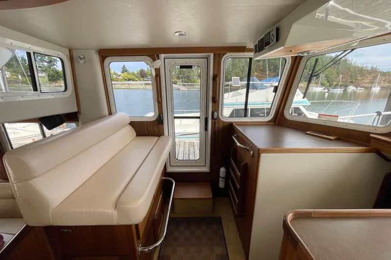 Slide: The Image of Interior of 2013 American Tug 395, featuring seating and scenic marina view. - 38