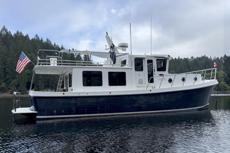 Slide: The Image of 2013 American Tug 395 boat on calm water with forested background. - 4