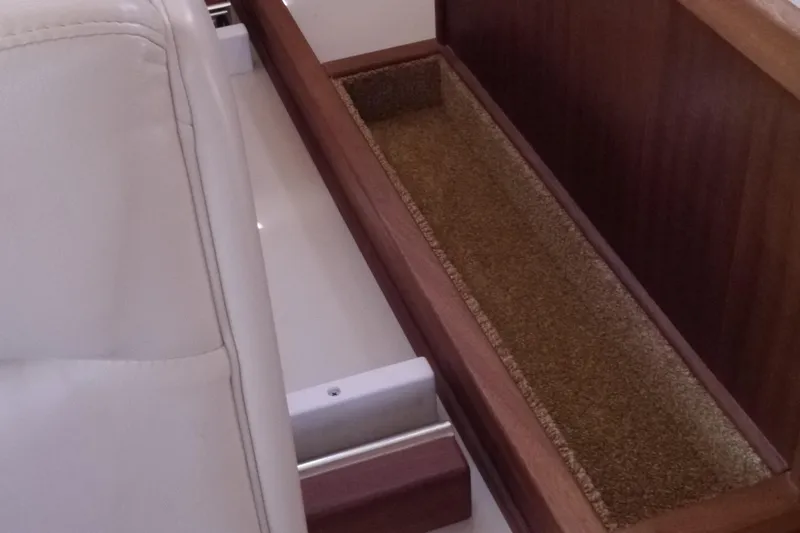 Slide: The Image of Interior view of 2013 American Tug 395 with wooden storage compartment and white seating. - 59