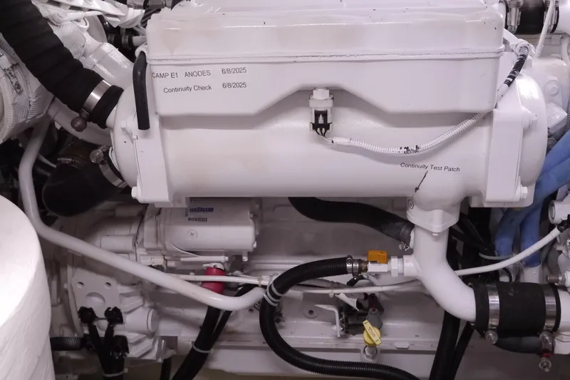 Slide: The Image of Engine compartment of a 2013 American Tug 395, featuring various mechanical components and hoses. - 65