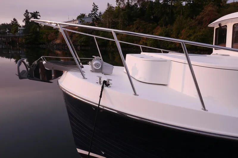 Slide: The Image of 2013 American Tug 395 boat docked, featuring sleek design and stainless steel railings. - 7