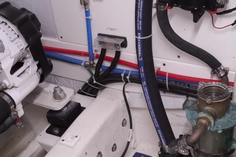 Slide: The Image of Engine room of 2013 American Tug 395 with visible hoses and mechanical components. - 79