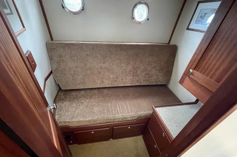 Slide: The Image of Cozy cabin interior of 2013 American Tug 395 with portholes and wooden cabinetry. - 90