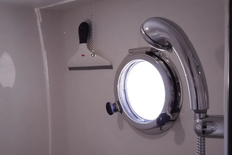 Slide: The Image of Porthole and shower fixture in 2013 American Tug 395 boat bathroom. - 93