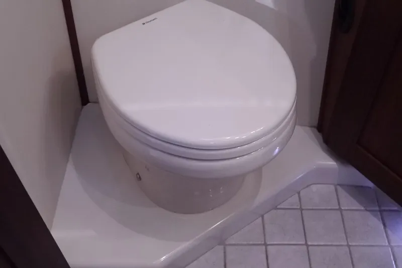 Slide: The Image of Toilet in 2013 American Tug 395 boat bathroom, featuring tiled floor and compact design. - 94