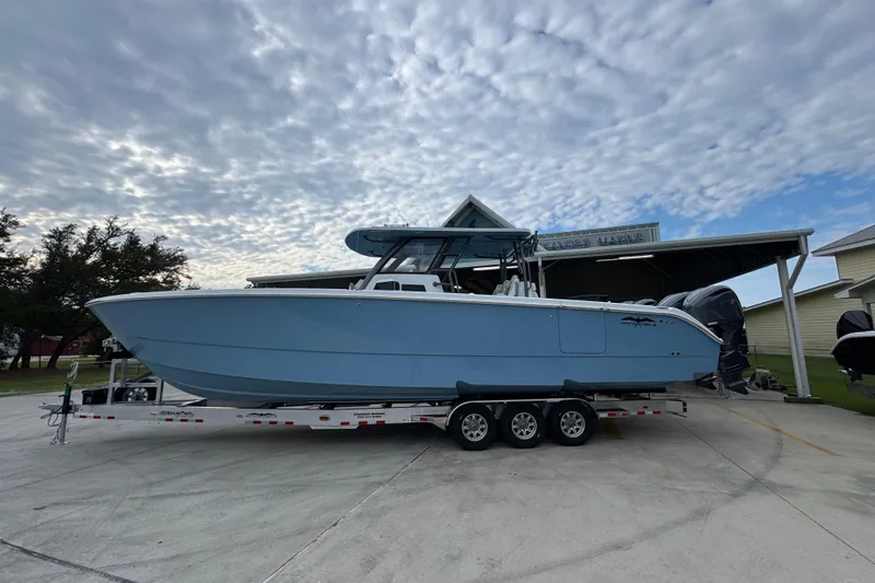 The Image of 2026 Invincible 38 Catamaran on trailer, parked outdoors under cloudy sky. - 1