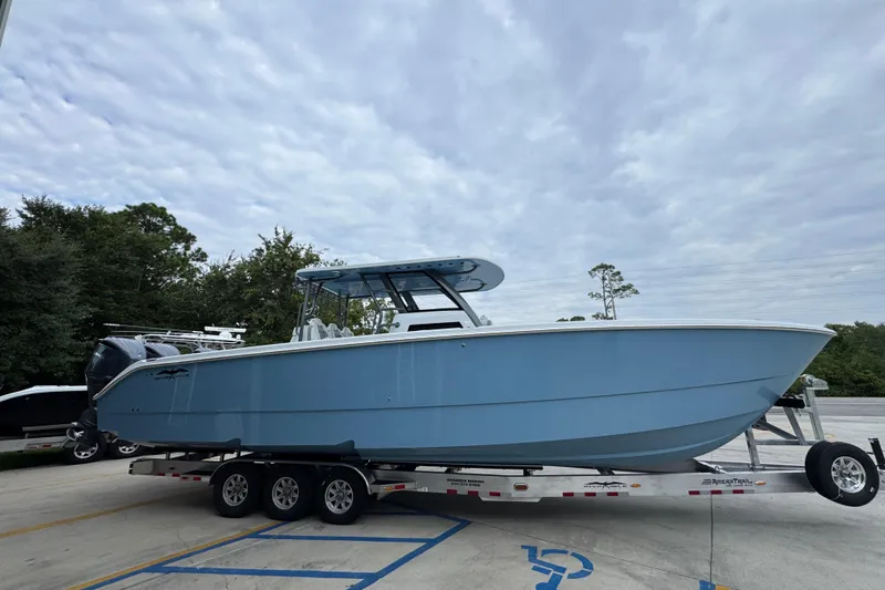 Slide: The Image of 2026 Invincible 38 Catamaran on trailer, sleek design, light blue hull, parked outdoors. - 10