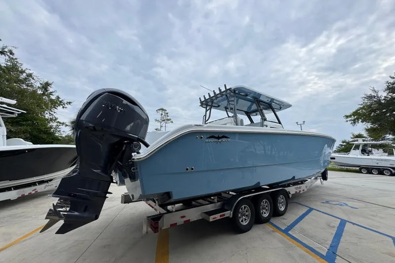 Slide: The Image of 2026 Invincible 38 Catamaran with Yamaha engine on trailer, parked outdoors. - 12