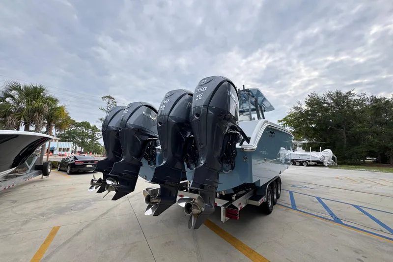 Slide: The Image of 2026 Invincible 38 Catamaran with triple Yamaha engines on a trailer, parked outdoors. - 13